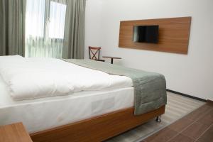 a bedroom with a bed and a tv on the wall at BUSINESS EXPRESS HOTEL in Tekirdag