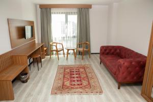 uma sala de estar com um sofá vermelho e um piano em BUSINESS EXPRESS HOTEL em Tekirdağ