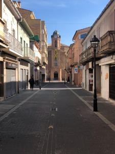 an empty street with a building with a clock tower at Apartamento familiar con Wifi in Navás