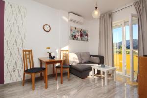 a living room with a couch and a table and chairs at Apartments Brnic in Baška
