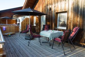 a table and chairs with an umbrella on a deck at Naturlaub.pur in Waldmünchen
