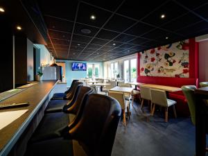 een restaurant met stoelen en tafels en een bar bij Kyriad DIRECT Saint Brieuc - Parc des Expositions in Tregueux