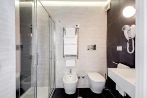 La salle de bains est pourvue de toilettes, d'un lavabo et d'une douche. dans l'établissement Albergo Abruzzi, à Rome