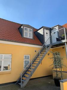 a house with a staircase on the side of it at Hyggelig 1.sals lejlighed i Varde midtby. in Varde