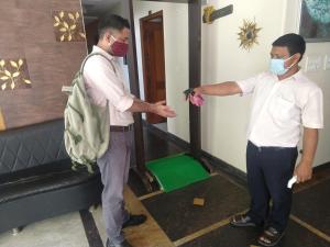 two men wearing masks in a hotel room at Hotel Persona International in New Delhi