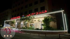 a building with a neon sign on the side of it at Al Azhar Hotel Jeddah in Jeddah