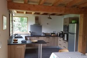 a kitchen with a table and a refrigerator at Chalet l'ecrin - 6 pers with panoramic view of the Meije in La Grave