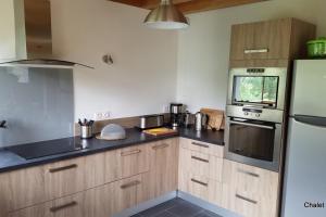 a kitchen with wooden cabinets and a white refrigerator at Chalet l'ecrin - 6 pers with panoramic view of the Meije in La Grave