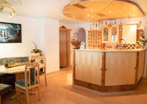 a kitchen with a bar and a dining room at Apart Garni Wiesenhof in Kappl