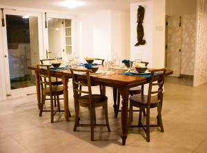 a wooden dining room table with chairs and wine glasses at Villa Lewis in Badulla