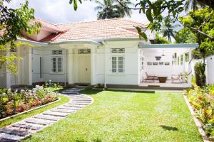 a white house with a green yard at Villa Lewis in Badulla