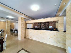 eine Bar in einem Restaurant mit einer Steinmauer in der Unterkunft ARI EVENTS in Căşeiu