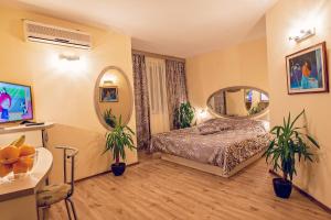 Hotel Color في مدينة فارنا: غرفة نوم بسرير ومرآة دائرية