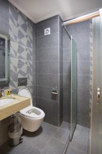 a bathroom with a toilet, shower, and sink at T-Square Residence in Istanbul