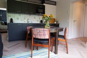 a kitchen with a table with chairs and a vase of flowers at B&B Doremi in Kaatsheuvel