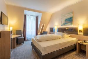 a hotel room with a bed and a desk at Parkhotel Berghölzchen in Hildesheim +58 photos
