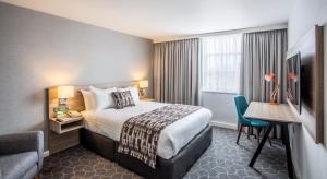 a hotel room with a bed and a desk at Holiday Inn Ellesmere Port/Cheshire Oaks by IHG in Ellesmere Port
