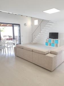 salon z dużą kanapą i schodami w obiekcie Appartamento da sogno nel Resort Marinagri w mieście Policoro