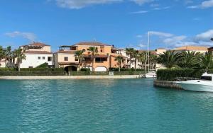 łódź w wodzie przed niektórymi domami w obiekcie Appartamento da sogno nel Resort Marinagri w mieście Policoro +12 zdjęć