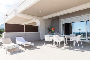 een patio met een tafel en stoelen op een balkon bij Cavalluccio Marino in Mazzeo