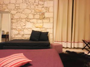 I Santi Coronati في سيراكوزا: غرفة معيشة مع أريكة وجدار حجري