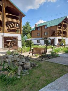 un parque con un banco frente a un edificio en Edelweiss Carpathians Migovo, en Migovo