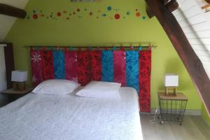een slaapkamer met een bed met een rood en blauw gordijn bij La longère de Crisolles in Crisolles