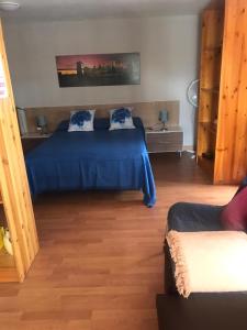 a bedroom with a blue bed and a couch at APARTAMENTO EN LA LAGUNA in Las Lagunas