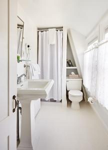 Baño blanco con lavabo y aseo en Cliff Lodge, en Nantucket