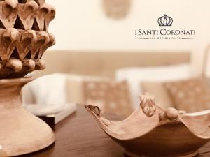 シラクーサにあるイ サンティ コロナーティの壷の横のテーブルに座る木鉢