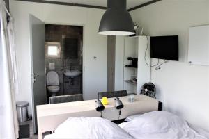 1 dormitorio con 1 cama y baño con lavamanos en Panorama Box op Camping de Stal, en Drijber