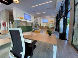 an office with a wooden desk with a laptop on it at Villa Alojamiento y Congresos - Villa Universitaria in San Vicente del Raspeig