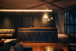 a living room with a couch and a mirror at HOTEL KARUIZAWA CROSS in Karuizawa