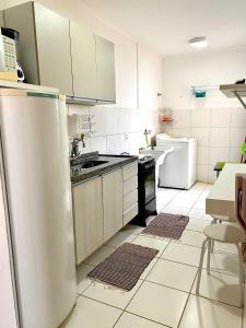 a kitchen with a refrigerator and a sink in it at Apto Temp itapira e circuito das águas EUROVILE in Itapira