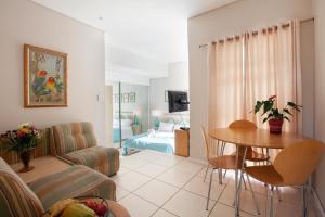 ein Wohnzimmer mit einem Sofa und einem Tisch in der Unterkunft 20AB Belladonna Apartments Vredehoek Cape Town in Kapstadt