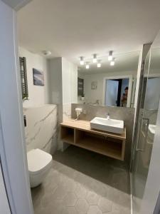 a bathroom with a toilet and a sink and a mirror at Apartamenty MGA ApartPark in Świnoujście
