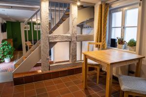 a dining room with a table and a staircase at Fachwerkhotel - Ferienhäuser Vorhof zur Hölle in Quedlinburg