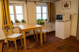cocina con mesa, nevera y microondas en Fachwerkhotel - Ferienhäuser Vorhof zur Hölle, en Quedlinburg
