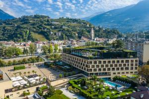 eine Luftansicht einer Stadt mit Bergen im Hintergrund in der Unterkunft Hotel Therme Meran - Terme Merano in Meran