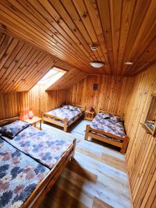 Habitación con 2 camas en una habitación de madera en Kunči, en Priekuļi