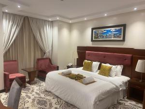 ein Hotelzimmer mit einem großen Bett und einem Stuhl in der Unterkunft رميس للشقق المخدومة 2 in Buraida + 59 Fotos