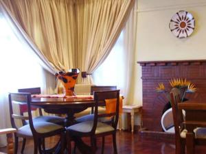 a dining room with a table and chairs and a fireplace at MS Self-Catering in Pietermaritzburg