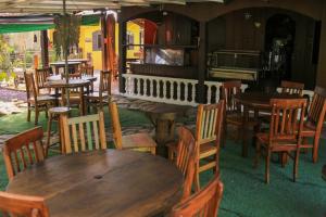 um restaurante com mesas e cadeiras de madeira e um piano em Pousada Bob Pai & Bob Filho na Ilha do Mel