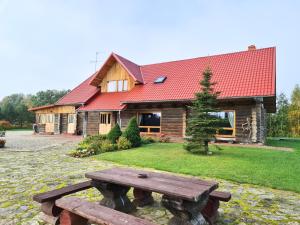 una casa de madera con una mesa de picnic delante de ella en Kunči, en Priekuļi