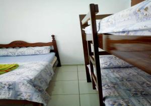 a bedroom with two bunk beds in a room at Pousada Brasil - Self Check-in in Aparecida