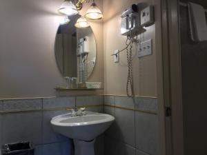 a bathroom with a sink and a mirror at La Roma Motel in Edmundston