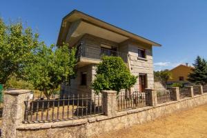 a stone house with a fence in front of it at Casa Rural Picape in Pedre