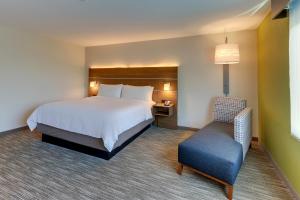 a hotel room with a bed and a chair at Holiday Inn Express & Suites - Roanoke – Civic Center in Roanoke