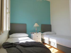 twee bedden in een kamer met blauwe muren bij Montegrappa Apartment in Bologna