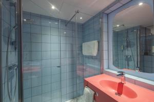a bathroom with a shower, sink, and tub at prizeotel München-Airport in Hallbergmoos
